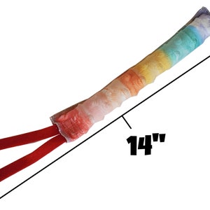 May include: A rainbow-colored dog toy with a red fabric handle. The toy is 14 inches long.