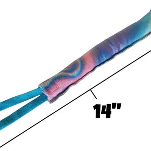 May include: A 14-inch long dog toy with a blue and pink tie-dye pattern and two blue straps.