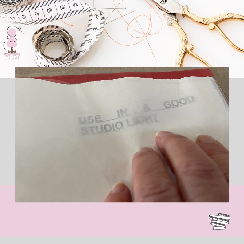 Op de afbeelding: Een close-up van een wit vel papier met de woorden "USE IN STUDIO LIGHT GOOD" erop gedrukt. Een hand raakt het papier.