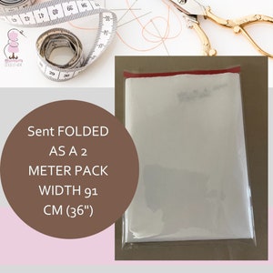Op de afbeelding: Een witte stof gevouwen en verpakt in een doorzichtige plastic zak met een rode streep aan de bovenkant. De zak is gelabeld "Sent FOLDED AS A 2 METER PACK WIDTH 91 CM (36")".