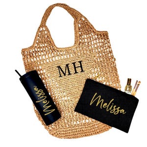 May include: A brown crocheted tote bag with the initials "MH" embroidered on the front. The bag is filled with a black tumbler with the name "Melissa" in gold lettering, a black makeup bag with the name "Melissa" in gold lettering, and a small bottle of nail polish and makeup brushes.