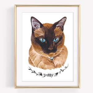 May include: Watercolor portrait of a Siamese cat with striking blue eyes, brown and tan fur, and a small bell collar. The artwork is framed in a gold-colored frame and includes the name "Dobby" in script below the cat.