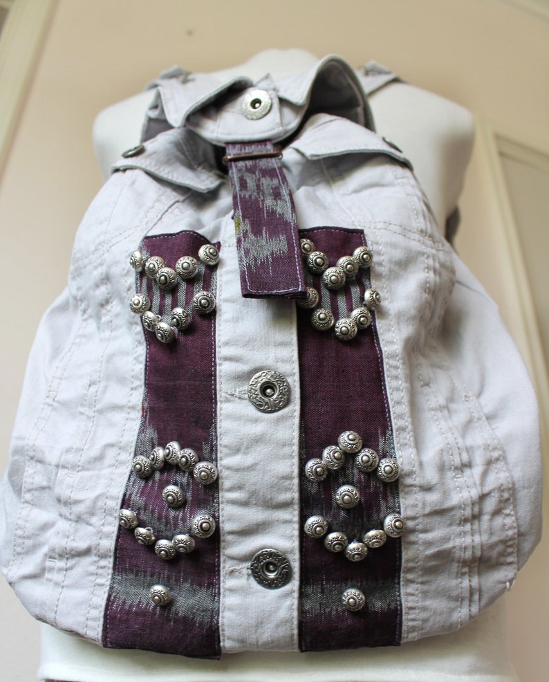 Handmade unique gray denim backpack with purple accents and embellishments