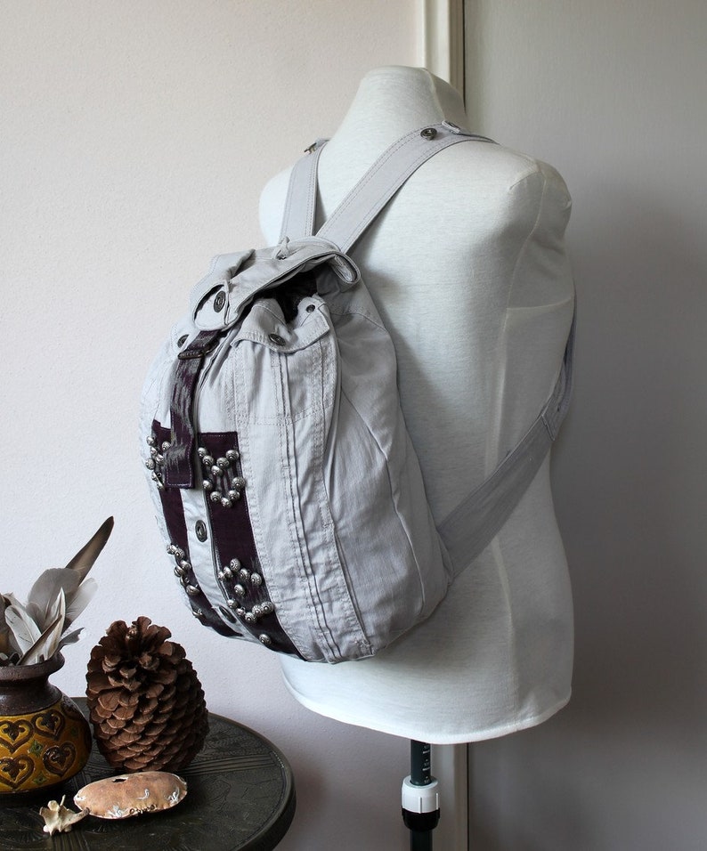 Handmade unique gray denim backpack with purple accents and embellishments