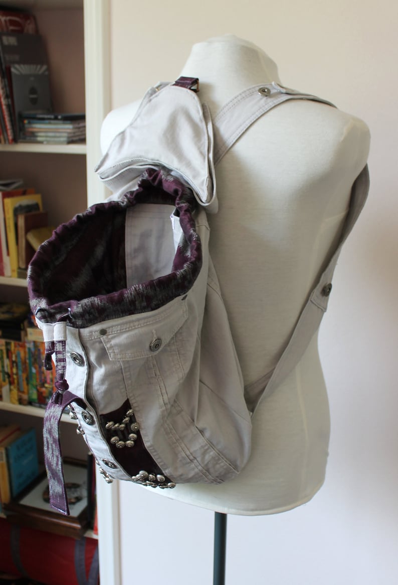 Handmade unique gray denim backpack with purple accents and embellishments