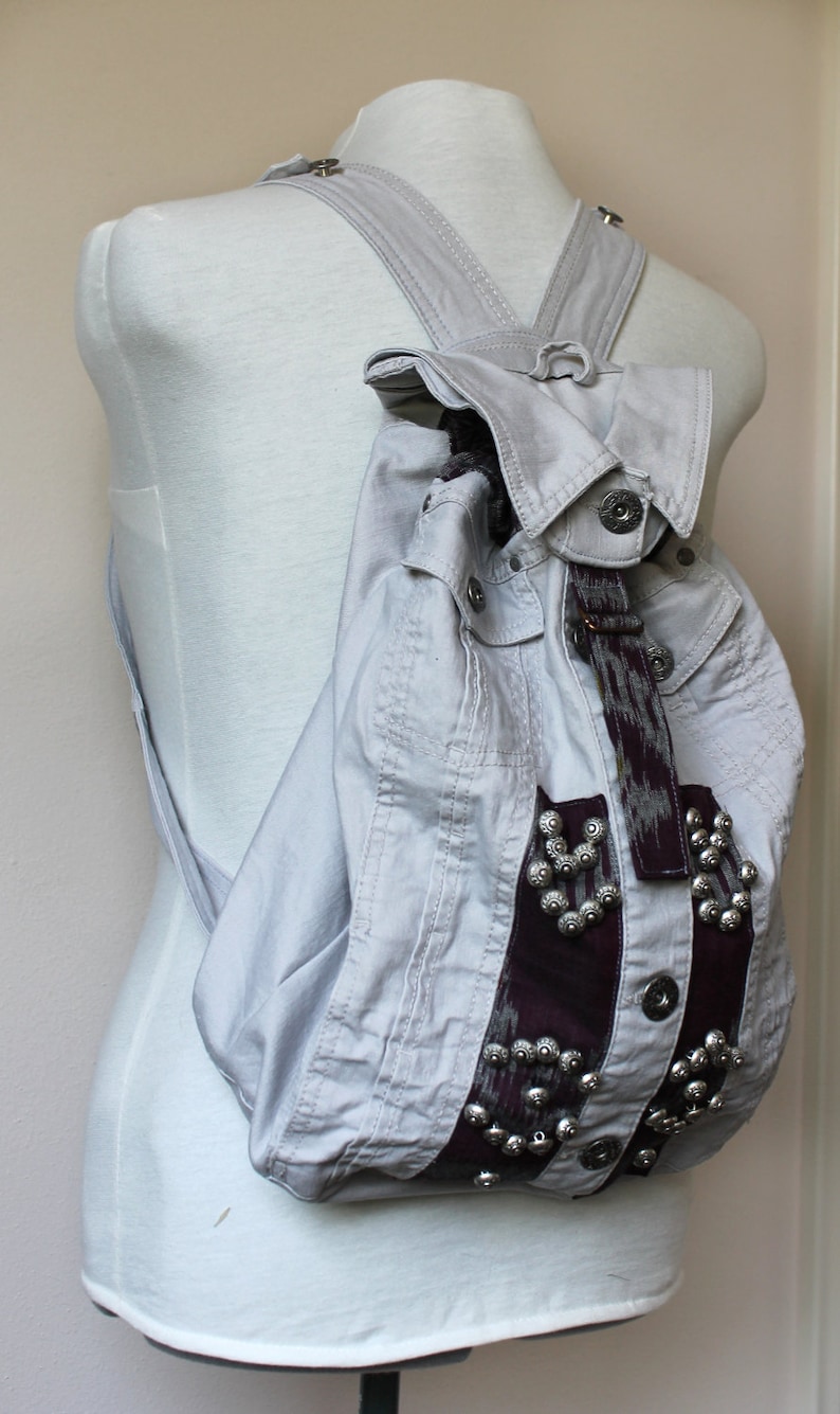 Handmade unique gray denim backpack with purple accents and embellishments