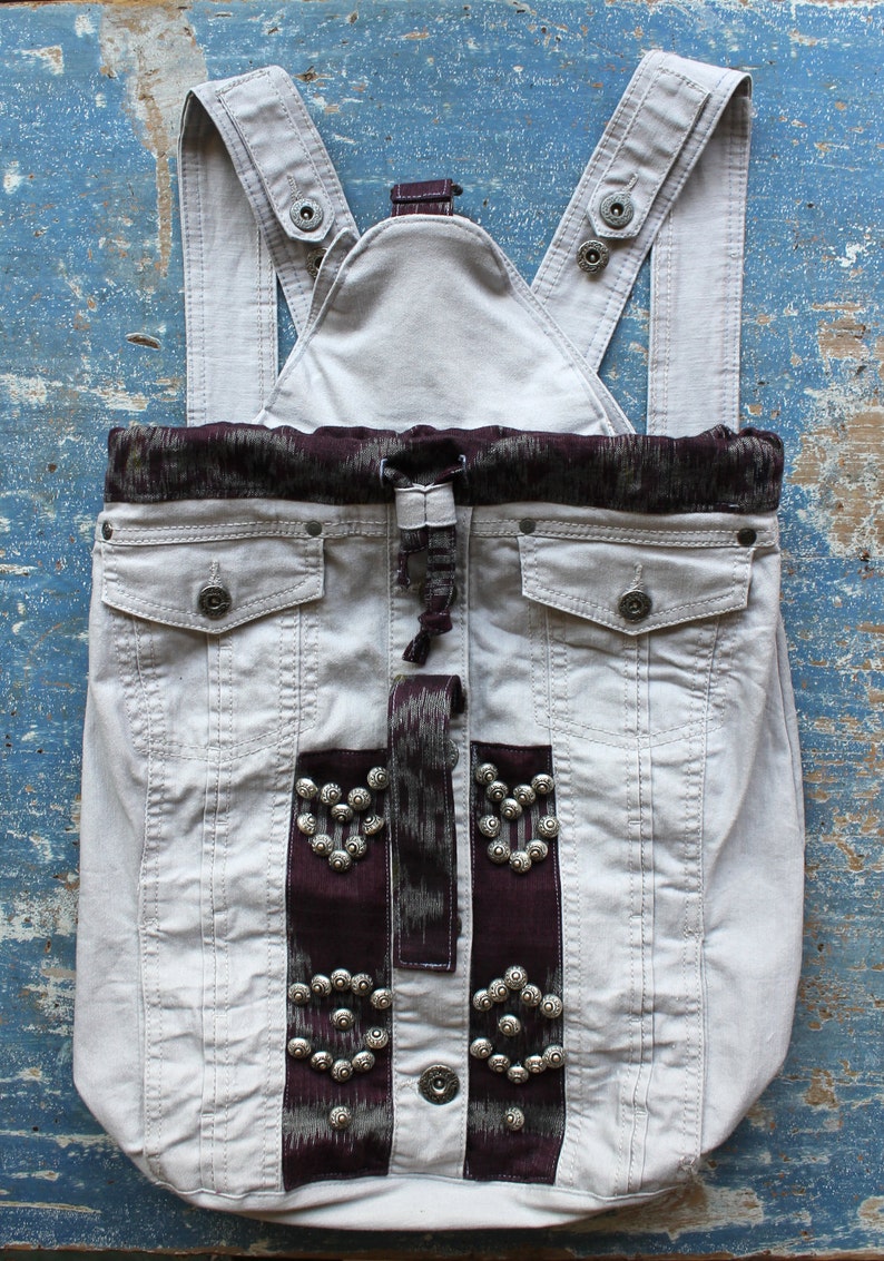 Handmade unique gray denim backpack with purple accents and embellishments
