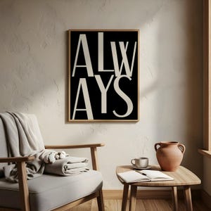 Puede incluir: Una impresión artística enmarcada con la palabra "ALWAYS" en una fuente audaz y moderna. La palabra está dividida en dos líneas, con letras color crema sobre un fondo negro. La impresión se exhibe en una habitación con una paleta de colores neutros.