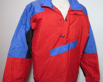 May include: A color-blocked jacket in red, blue, and black. The jacket has a high collar, snap closures, and a front pocket. The sleeves are long, and the jacket appears to be made of a lightweight, possibly water-resistant material.