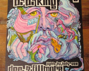 Peut inclure: Affiche de concert vintage pour The Byrds, Electric Flag et B.B. King, présentée par Bill Graham à San Francisco. L'œuvre psychédélique présente un visage coloré avec des yeux jaunes, une guitare et les dates de l'événement : 7 déc. Fillmore, 8-9 déc. Winterland.
