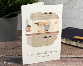 Könnte beinhalten: Eine weiße Grußkarte mit einem hölzernen Standmixer-Ausschnitt über einer Küchenillustration. Der Text lautet Made Especially For You und HAPPY BIRTHDAY in schwarzer Schrift. Die Karte hat ein klares Design mit einer neutralen Farbpalette.