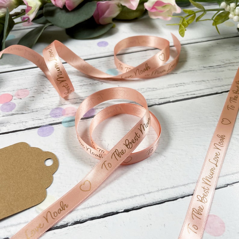May include: Pink satin ribbon with gold lettering that reads "To The Best Mum Love Noah".
