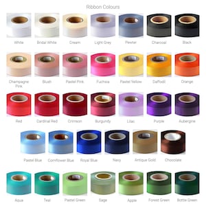 K&ouml;nnte beinhalten: Eine Sammlung von Bandrollen, die in einem Raster angeordnet und mit Farbnamen beschriftet sind, darunter White, Bridal White, Cream, Light Grey, Pewter, Charcoal, Black, Champagne Pink, Blush, Pastel Pink, Fuchsia, Pastel Yellow, Daffodil, Orange, Red, Cardinal Red, Crimson, Burgundy, Lilac, Purple, Aubergine, Pastel Blue, Cornflower Blue, Royal Blue, Navy, Antique Gold, Chocolate, Aqua, Teal, Pastel Green, Sage, Apple, Forest Green und Bottle Green.