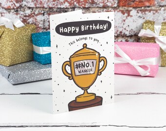 Könnte beinhalten: Eine weiße Geburtstagskarte mit einer Cartoon-Illustration eines goldenen Pokals auf einem braunen Sockel. Der Text lautet Happy Birthday! This belongs to you... und #No.1 WANKER auf dem Pokal. Die Karte ist mit kleinen schwarzen Sternen verziert.