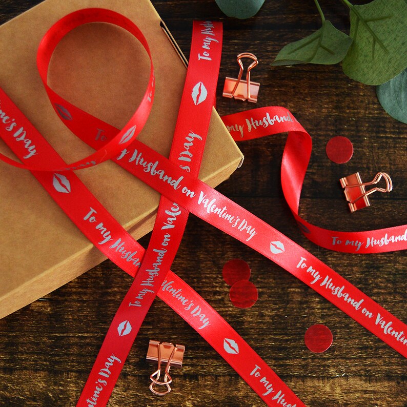 May include: Red satin ribbon with silver text that reads "To my Husband on Valentine's Day". The ribbon is decorated with silver lips.
