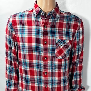 May include: A red, blue, and white plaid long-sleeve button-down shirt.