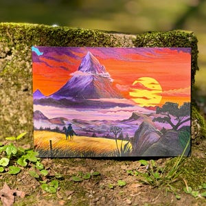 Peut inclure: Une peinture de paysage représente une chaîne de montagnes sous un coucher de soleil vibrant. L'œuvre présente une grande montagne, un soleil couchant et deux personnages à cheval. La palette de couleurs comprend des tons orange, violets et jaunes, créant une scène chaleureuse.