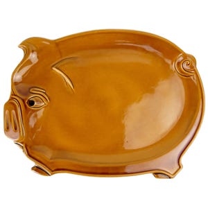 Puede incluir: Una fuente de cerámica con forma de cerdo. La fuente es de color marrón cálido y brillante. Presenta rasgos faciales detallados, incluyendo ojos, hocico y orejas. El plato con forma de cerdo está diseñado para servir alimentos.