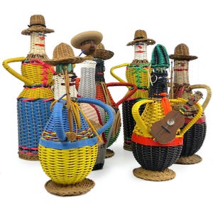 May include: A collection of seven decorative figurines crafted from woven wicker and plastic strips. Each figure features a bottle-shaped body, a wide-brimmed hat, and vibrant colours including yellow, blue, black, red, and white. One figure holds a small wooden guitar.