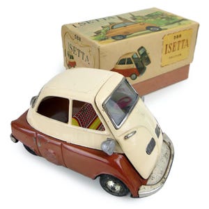 Peut inclure: Une voiture jouet vintage, une Isetta rouge et blanche, avec un moteur à friction, dans sa boîte d'origine. La boîte est étiquetée "588 Isetta Friction".