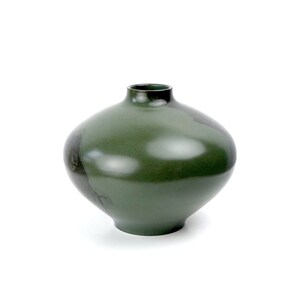 May include: A dark green ceramic vase with a rounded, bulbous shape. The vase has a smooth, glossy finish and a subtle, uneven texture.