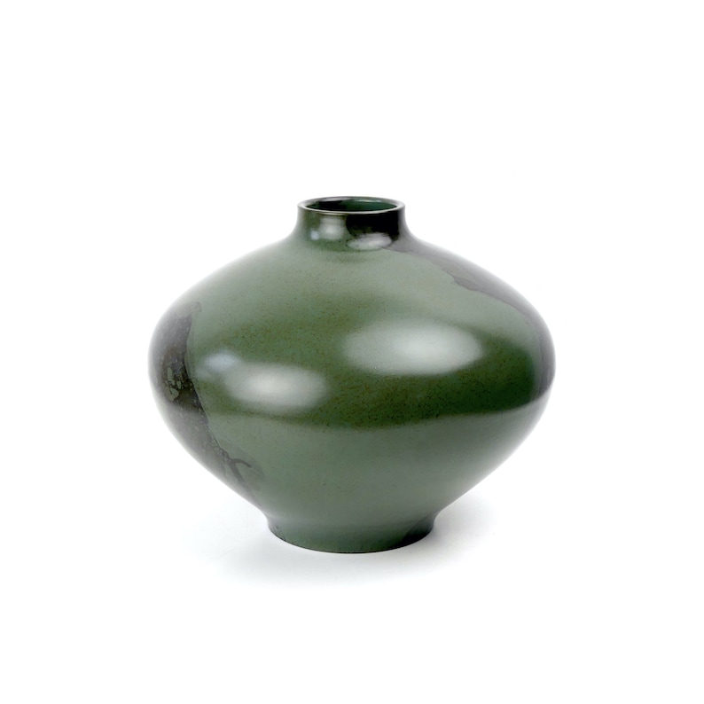 May include: A dark green ceramic vase with a rounded, bulbous shape. The vase has a smooth, glossy finish and a subtle, uneven texture.