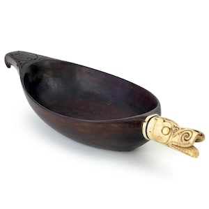 Può includere: Una ciotola di legno marrone scuro con un manico scolpito a forma di testa di drago in avorio. La ciotola è di forma ovale e ha una finitura liscia e lucida.