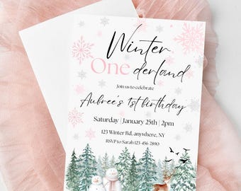 Op de afbeelding: Een roze en witte winterwonderland-thema eerste verjaardagsinvitation met sneeuwvlokken, een sneeuwpop, een hert en dennenbomen. De tekst luidt "Winter One derland" en "Aubree's 1st birthday".