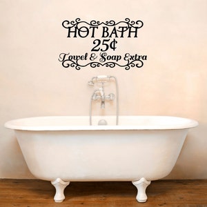 May include: A white clawfoot bathtub with a black and white sign above it that reads "HOT BATH 25¢ Towel & Soap Extra".