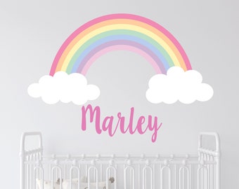 May include: A pink, rainbow wall decal with white clouds and the name "Marley" written in pink script.