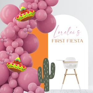 May include: A pink and green cactus cutout with the text "Lorelei's First Fiesta" on a white background with a pink balloon arch.