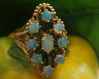 May include: A gold ring with a delicate filigree design and a cluster of blue opals.