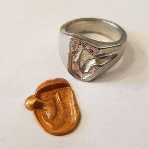 Anillo de sello de cera con la letra "J" en el cuerpo