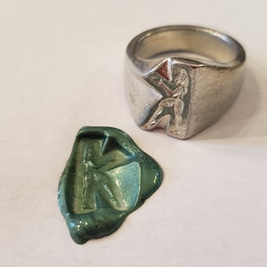 Anillo de sello de cera con la letra "k" en el cuerpo