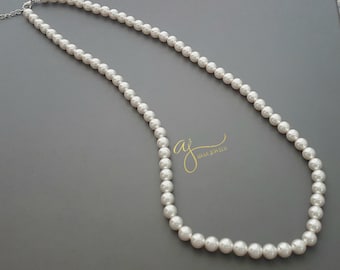 Könnte beinhalten: Eine weiße Perlenkette mit einem silbernen Verschluss. Die Kette besteht aus runden Perlen und ist etwa 45 cm lang.