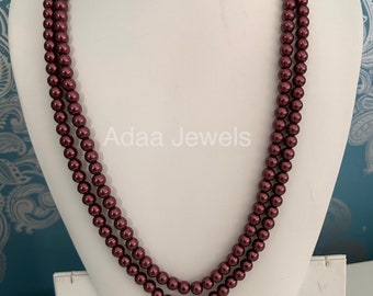 May include: A double strand necklace made of maroon colored faux pearls. The necklace is displayed on a white mannequin bust.