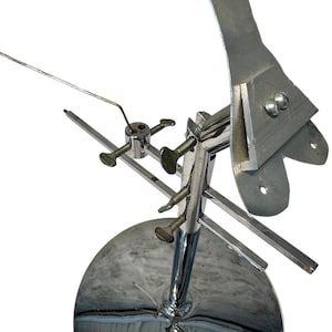 May include: A chrome-plated metal stand with a round base and adjustable arms. The stand has a long, thin metal rod extending from the top arm.