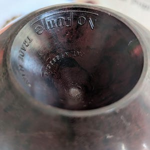 Peut inclure: Gros plan de l'int&eacute;rieur d'un objet rond en bois brun fonc&eacute;. L'objet porte les inscriptions "No fume" et "Pat. No. 1,955,918" &agrave; l'int&eacute;rieur.
