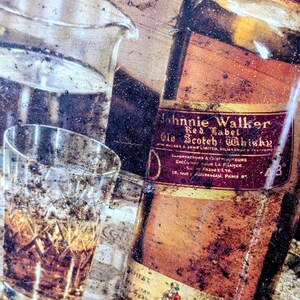 May include: An aged, vintage-style image featuring a bottle of Johnnie Walker Red Label Old Scotch Whisky, a glass of whisky, and a clear glass pitcher. The bottle has a red label with gold lettering. The image has a rustic, weathered appearance.