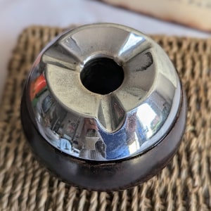 Peut inclure: Un cendrier vintage en chrome et bois avec une forme ronde et un bol profond. Le cendrier a une surface r&eacute;fl&eacute;chissante et une base en bois fonc&eacute;.
