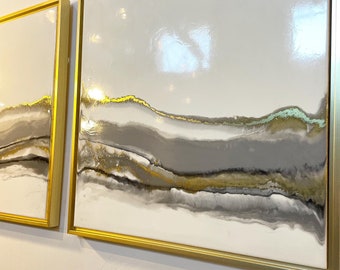 Puede incluir: Dos pinturas abstractas con fondo blanco y detalles en dorado, gris y verde. Las pinturas están enmarcadas en oro.