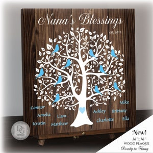 May include: A wooden plaque with a white tree design and blue birds. The plaque has the text "Nana's Blessings est. 2011" at the top and names of family members around the tree. The plaque is 16 inches by 16 inches and is ready to hang.