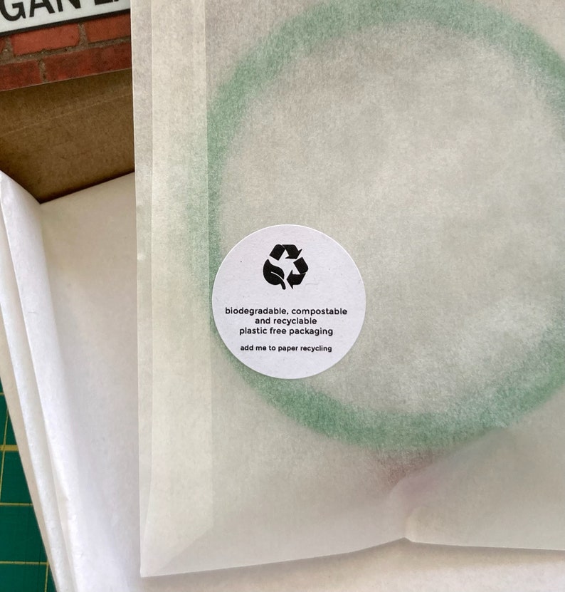May include: A white paper bag with a green circle on it. The circle has a recycling symbol and the text "biodegradable, compostable and recyclable plastic free packaging add me to paper recycling".