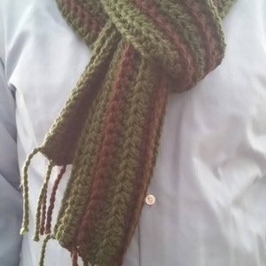 May include: A green and brown striped crocheted scarf with long fringe tassels.