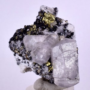May include: A cluster of clear, glassy, quartz crystals with a silvery sheen, surrounded by black and gold pyrite crystals.