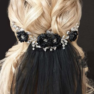 May include: Black bridal veil with a silver floral hair comb featuring black fabric flowers and rhinestones.