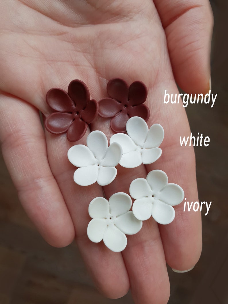 K&ouml;nnte beinhalten: Nahaufnahme von sechs bl&uuml;tenf&ouml;rmigen Bastelverzierungen in Burgunderrot, Wei&szlig; und Elfenbein. Die Bl&uuml;tenbl&auml;tter sind abgerundet und haben ein kleines Loch in der Mitte. Der Text "burgundy", "white" und "ivory" ist sichtbar.