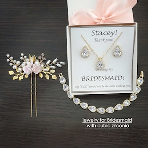 May include: A gift box with a pink ribbon and a card that says "Stacey! Thank you! For being my BRIDESMAID! My "I DO" would not be the same without you!" The box contains a gold necklace and earrings with cubic zirconia stones. The text "jewelry for Bridesmaid with cubic zirconia" is also included.