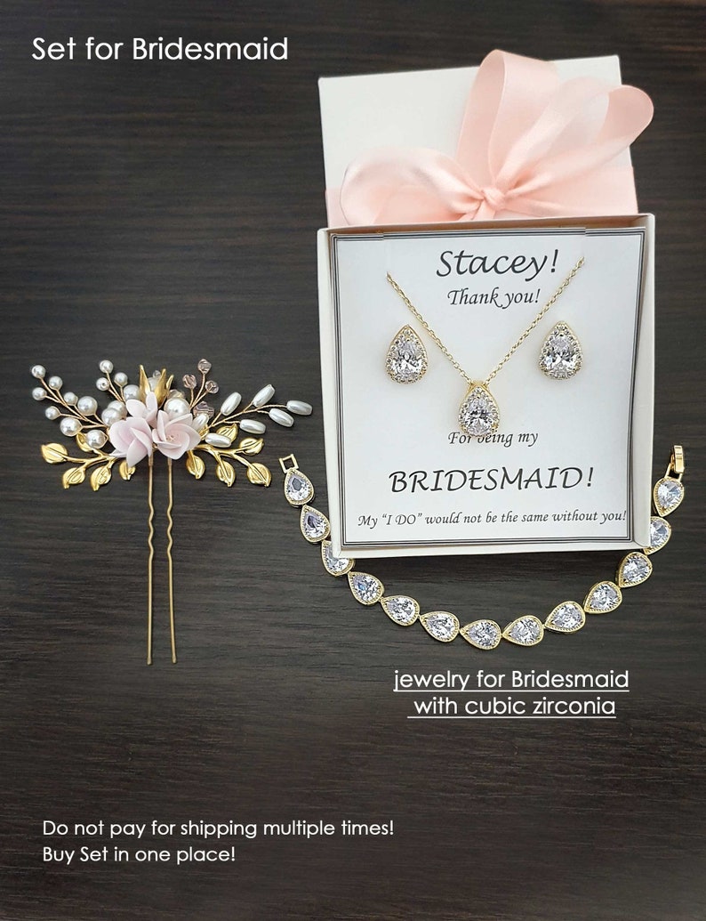 May include: A gift box with a pink ribbon and a card that says "Stacey! Thank you! For being my BRIDESMAID! My "I DO" would not be the same without you!" The box contains a gold necklace and earrings with cubic zirconia stones. The text "jewelry for Bridesmaid with cubic zirconia" is also included.