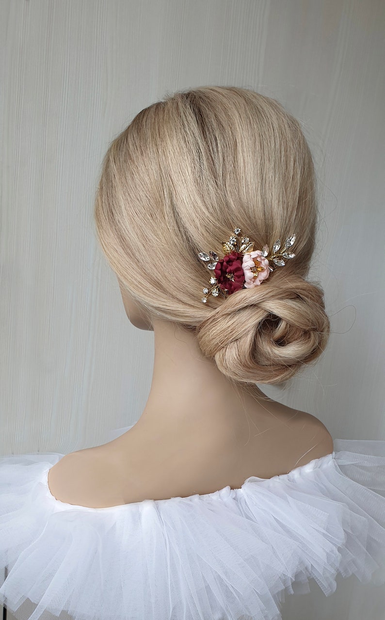 May include: A gold hair comb with burgundy and pink fabric flowers and rhinestones.